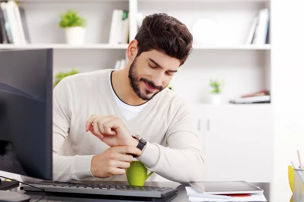 Jungunternehmer schaut auf seine Uhr. — Stockfoto