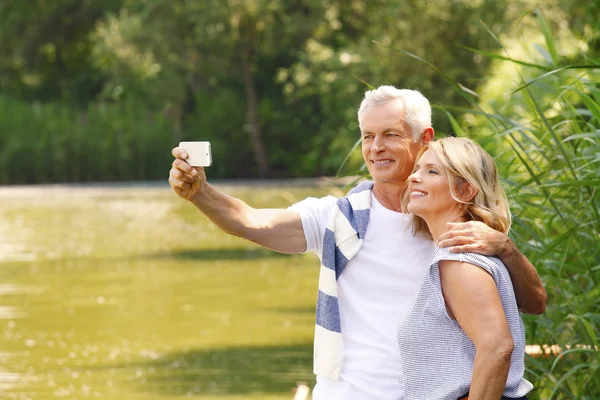 Couple aîné prendre autoportrait avec mobile — Photo