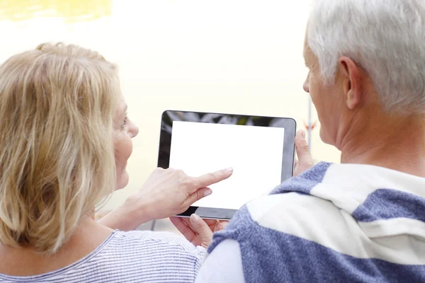 Lyckliga äldre par med digitala tablett — Stockfoto