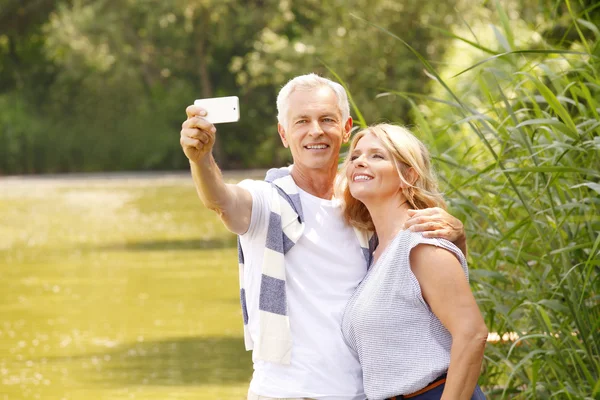 Feliz pareja de ancianos tomar selfie — Foto de Stock