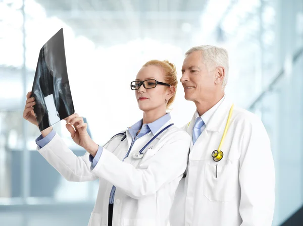 Female doctor standing with senior doctor — Stock Image Female doctor standing with senior doctor Stock Photo