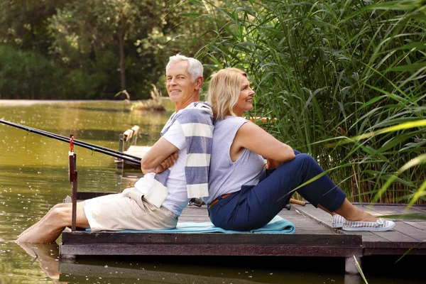 Senior couple sitting on the pier — Stock Photo, Image