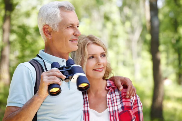 Happy senior people enjoying a walk in the forest — Stockfoto