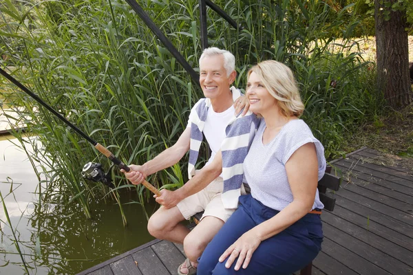 Senior couple relaxing at the lakeside — Stockfoto