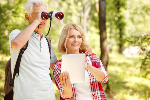 Happy senior people enjoying a walk in the forest