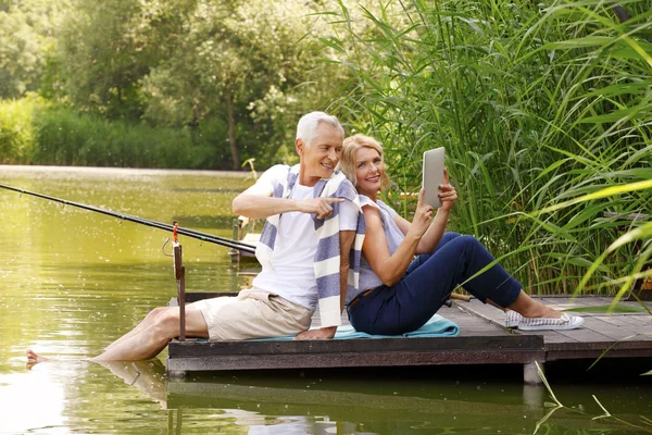 Senior couple relaxing on pier — Stock Photo, Image