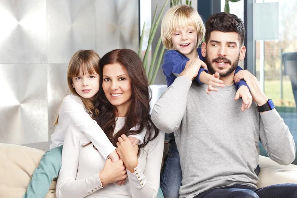 Young couple piggybacking their small children — Stock Photo, Image