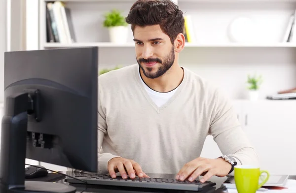 Joven empresario sentado en el lugar de trabajo — Foto de Stock