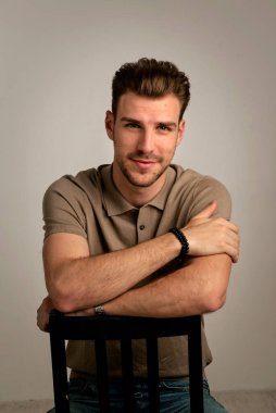 Stüdyoda poz verirken gülümseyen genç yakışıklı iş adamı. Genç girişimci iş kıyafeti giyiyor.. 