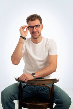 Işık odasında poz verirken gülümseyen genç girişimcinin portresi.