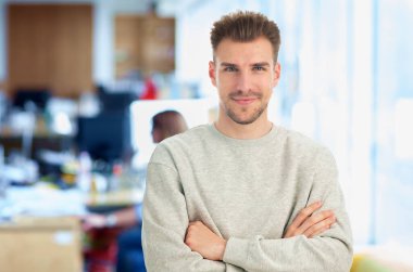 Modern ofiste poz veren kendinden emin genç iş adamının portresi. Genç girişimci iş kıyafeti giyiyor.. 