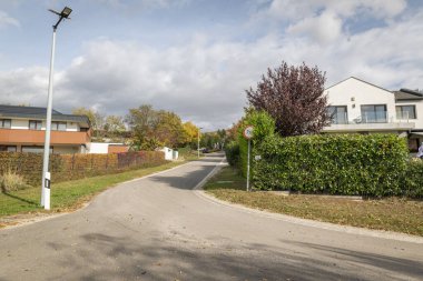 Bir yerleşim bölgesinde yol. Banliyöde sonbaharda ağaçlarla kaplı bir cadde. Boş sokak. 