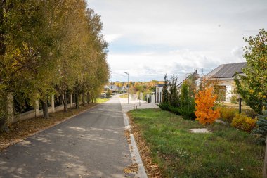 Bir yerleşim bölgesinde yol. Bir sonbahar günü bir evin çatısındaki yeni güneş panellerinin görüntüsü.