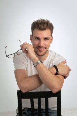 Sıradan kıyafetler giyen ve izole edilmiş beyaz arka planda oturan sakallı iş adamının portresi. Stüdyo çekimi, kopyalama alanı. Yakın plan..