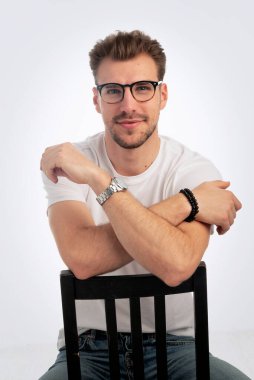 Sıradan kıyafetler giyen ve izole edilmiş beyaz arka planda oturan sakallı iş adamının portresi. Stüdyo çekimi, kopyalama alanı. Yakın plan..