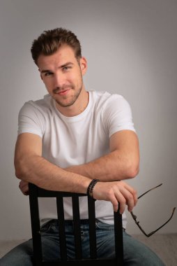 Sıradan kıyafetler giyen sakallı iş adamının portresi ve izole edilmiş arka planda oturmak. Stüdyo çekimi, kopyalama alanı. Yakın plan..