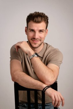 Sıradan kıyafetler giyen sakallı iş adamının portresi ve izole edilmiş arka planda oturmak. Stüdyo çekimi, kopyalama alanı. Yakın plan..