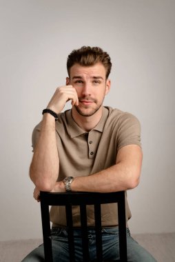 Sıradan kıyafetler giyen sakallı iş adamının portresi ve izole edilmiş arka planda oturmak. Stüdyo çekimi, kopyalama alanı. Yakın plan..