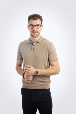 Tecrit edilmiş arka planda duran kendinden emin bir gencin portresi. Yakışıklı erkek iş kıyafeti giyiyor ve kameraya bakıyor. Uzayı kopyala Stüdyo çekimi.