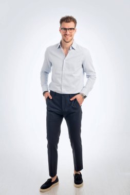 İş kıyafeti giymiş sakallı bir gencin portresi ve izole edilmiş beyaz arka plana karşı ayakta duruyor. Stüdyo çekimi, kopyalama alanı. Tam uzunluk.