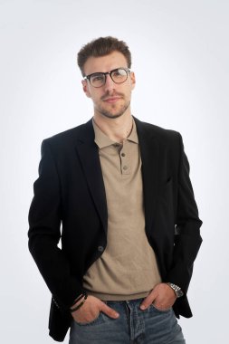 İş kıyafeti giymiş sakallı bir gencin portresi ve izole edilmiş beyaz arka plana karşı ayakta duruyor. Stüdyo görüntüsü, kopyalama alanı.