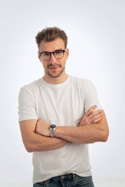 Sıradan kıyafetler giyen ve izole edilmiş beyaz arka planda duran sakallı bir gencin portresi. Beyaz gömlek ve kot pantolon. Stüdyo çekimi, kopyalama alanı. Yakın çekim..