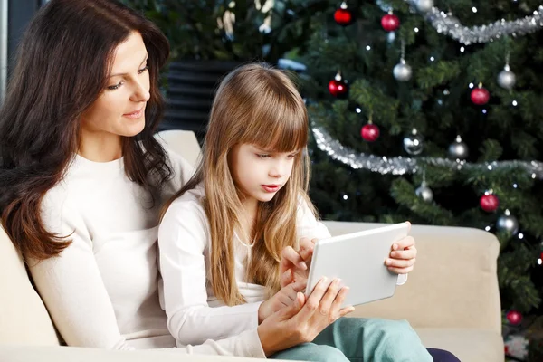 Mother and daughter next to christmas tree — Stock Photo, Image