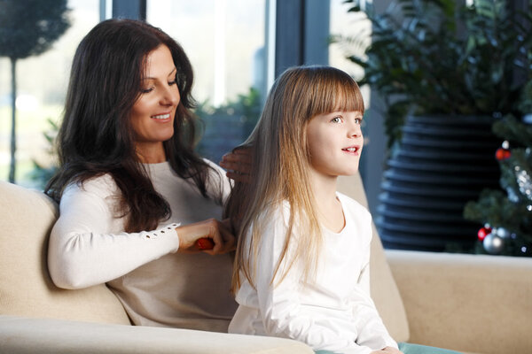 Мать и дочь рядом с рождественской елкой
.