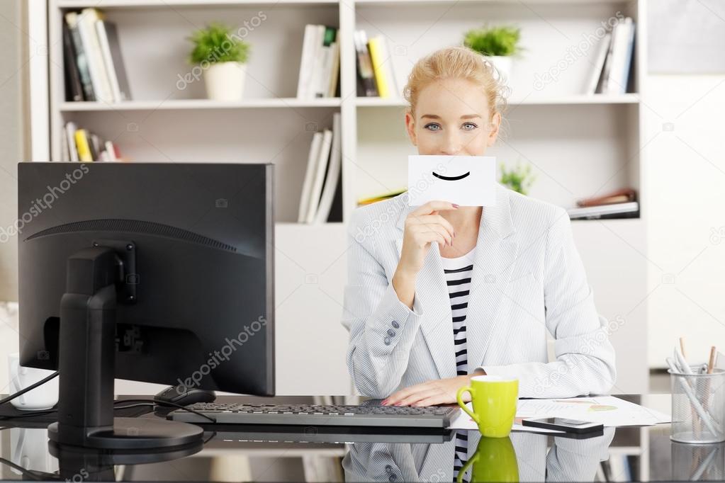 Businesswoman holding a smiley face icon card