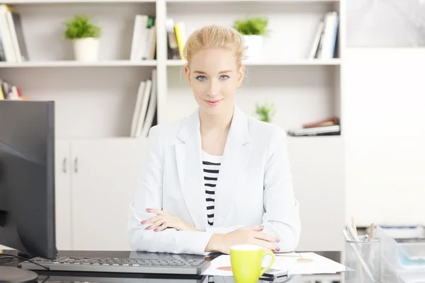 Professional woman sitting at desk — 图库照片