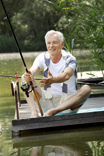湖畔で釣りの年配の男性. — ストック写真