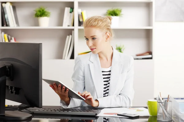 Jovem assistente trabalhando em tablet digital — Fotografia de Stock