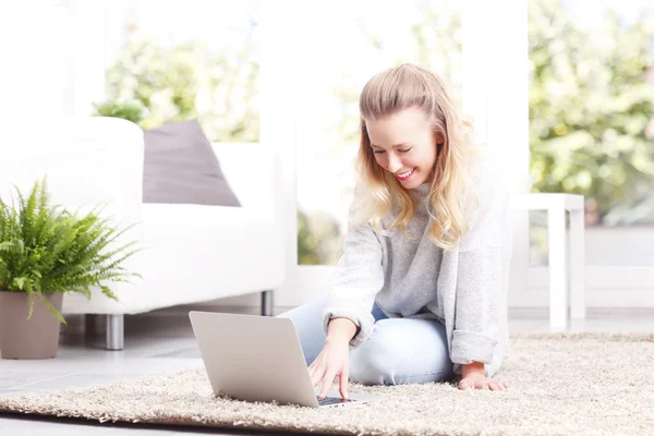 Woman reading news on laptop — Stock Photo, Image