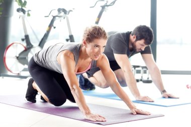 Erkek ve kadın birlikte spor salonunda eğitim.