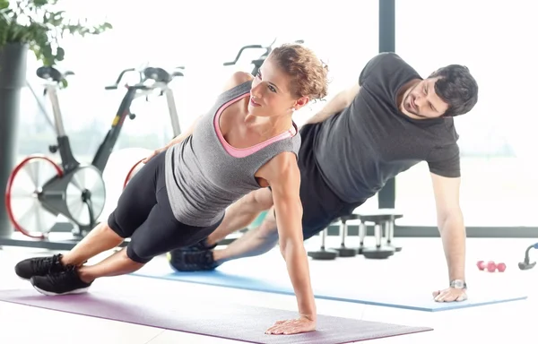 Man en een vrouw doen plank oefeningen — Stockfoto