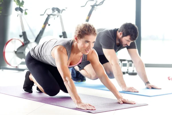 Erkek ve kadın birlikte spor salonunda eğitim.