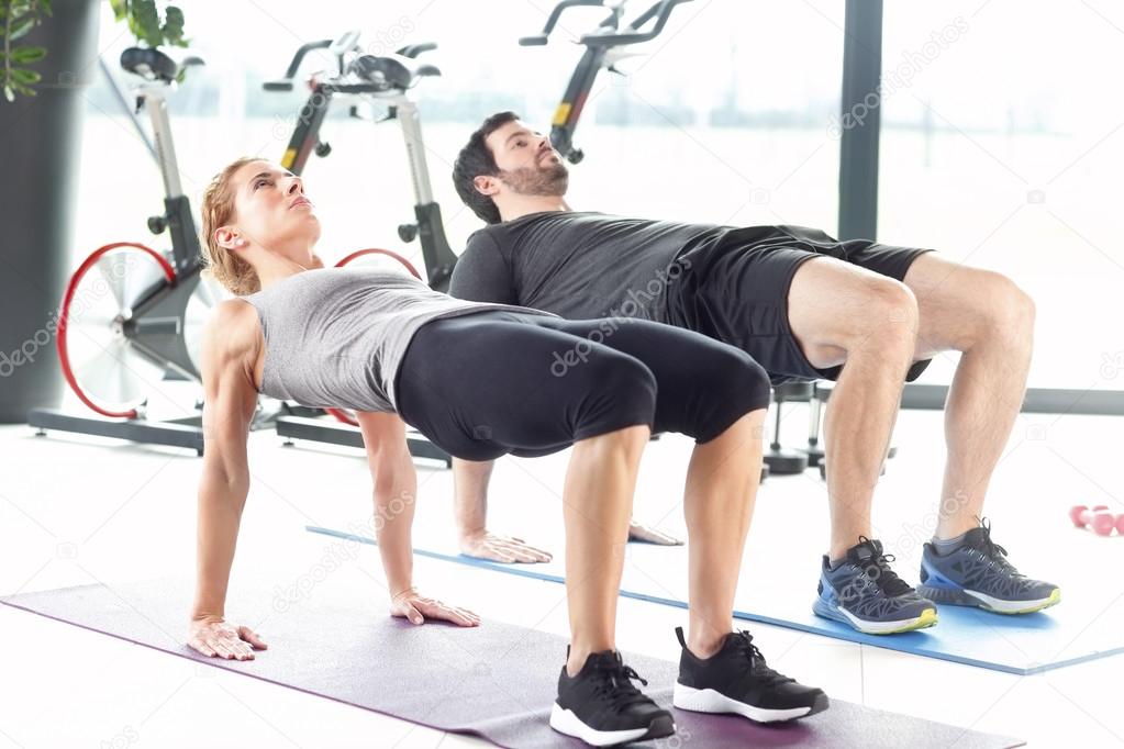 Man and woman training together at the gym.