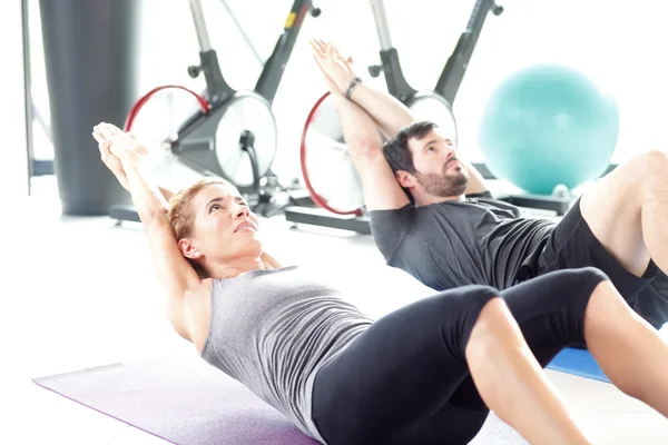 Hombre y mujer entrenando juntos en el gimnasio —  Fotos de Stock