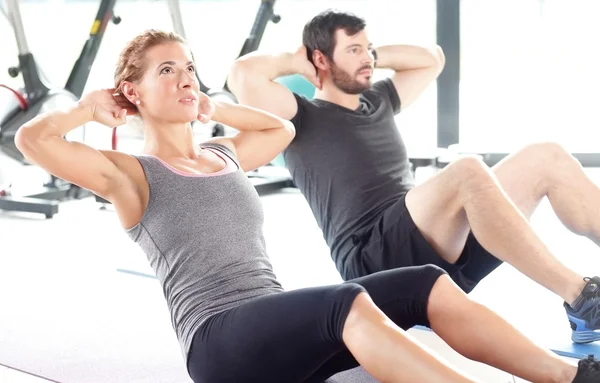 Hombre y mujer entrenando juntos en el gimnasio — Foto de Stock