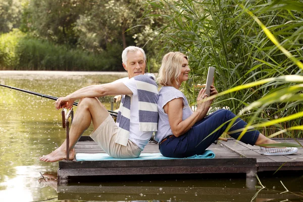 Heureux couple aîné se détendre au bord du lac — Photo
