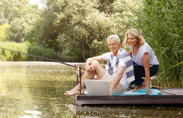 Senior people fishing while surfing on internet. — Stock Photo, Image