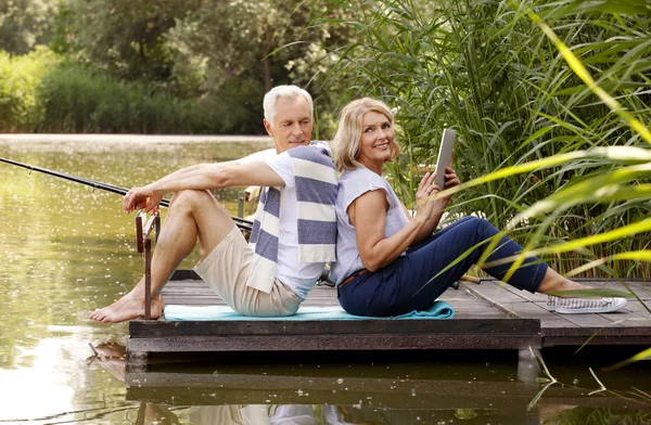 Heureux couple aîné se détendre au bord du lac — Photo