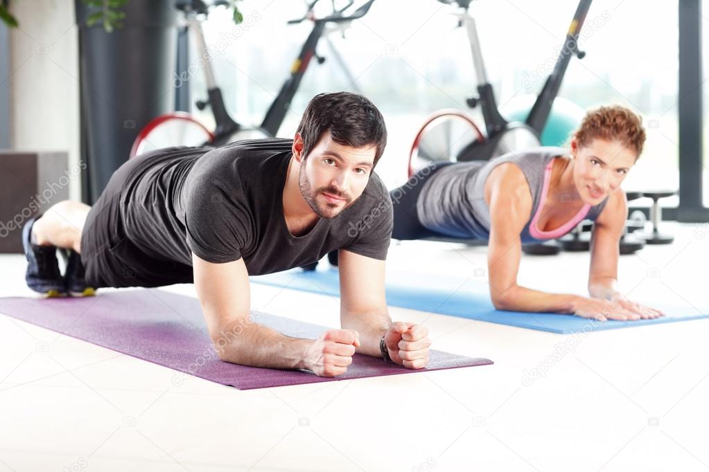 Man and woman training together at the gym
