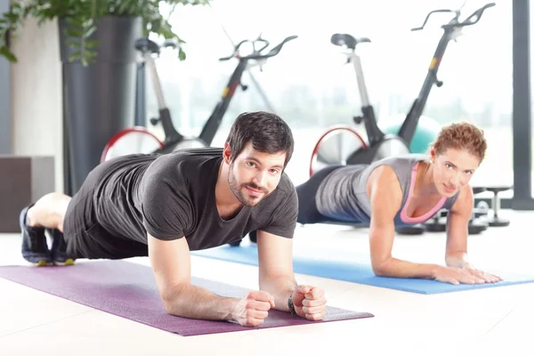 Mann und Frau trainieren gemeinsam im Fitnessstudio — Stockfoto