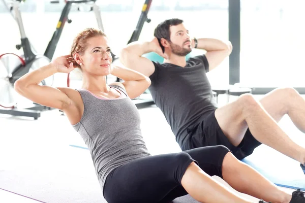 Hombre y mujer entrenando juntos en el gimnasio —  Fotos de Stock