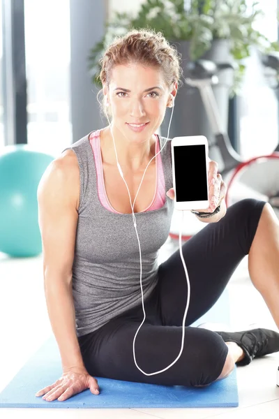 Vrouw luisteren muziek na fitnesstraining — Stockfoto