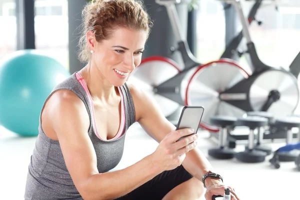 Personlig tränare kvinna sitter på gym — Stockfoto