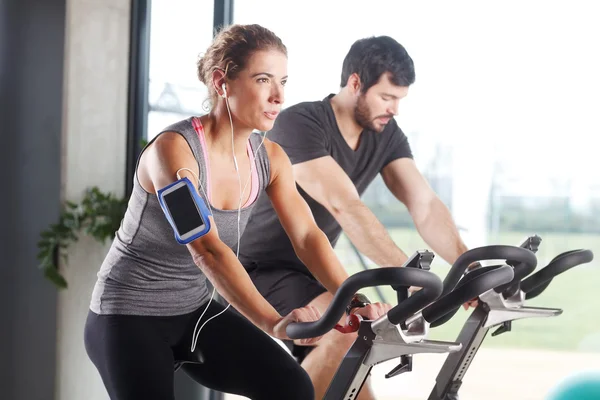 Miembros del gimnasio que participan en una clase de spinning — Foto de Stock