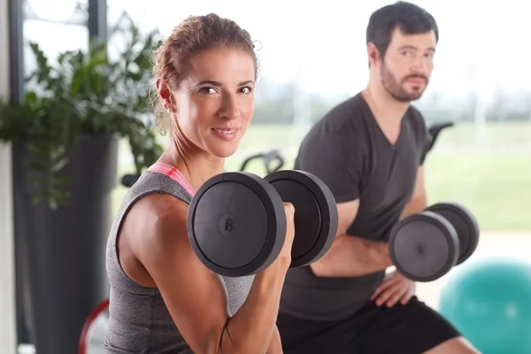 Žena a muž barbells zvedání — Stock fotografie