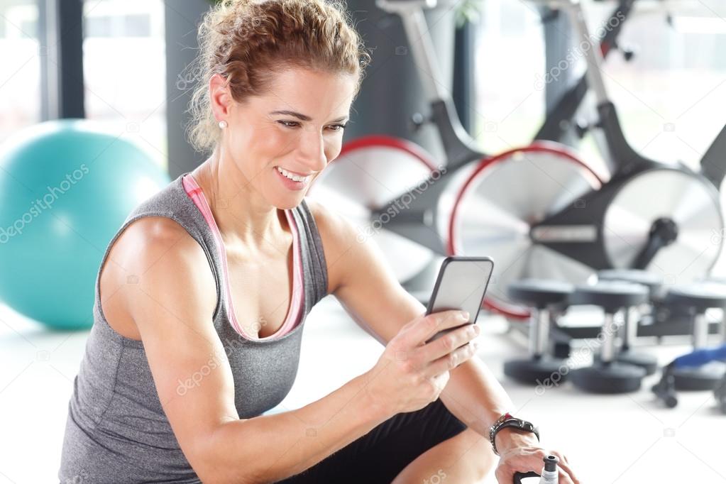 Personal trainer woman sitting at gym
